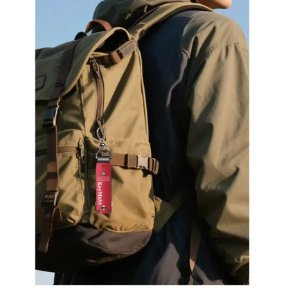 Hátizsákos túrázó kabátban, barna hátizsákon piros KeyMate kulcstartóval